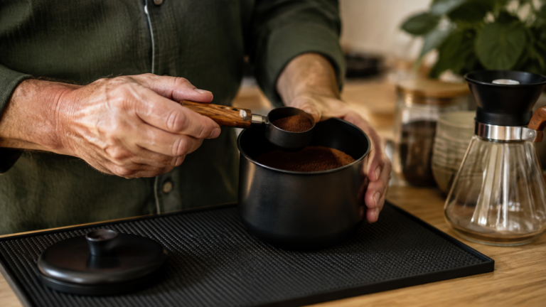 Mãos idosas segurando uma caneca com proteção de silicone